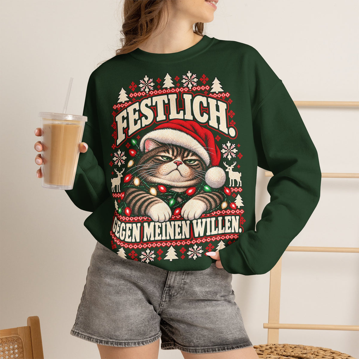 Woman wearing a forest green Christmas sweatshirt with German Festlich Gegen meinen Willen grumpy cat design
