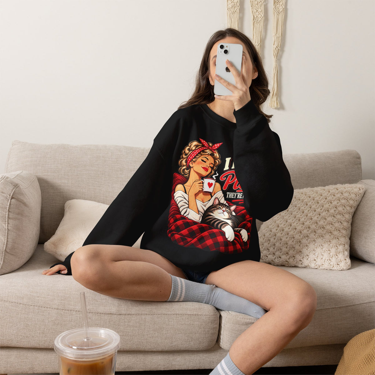 Woman relaxing at home in a black retro cat sweatshirt with I Have Plans They’re at Home graphic.