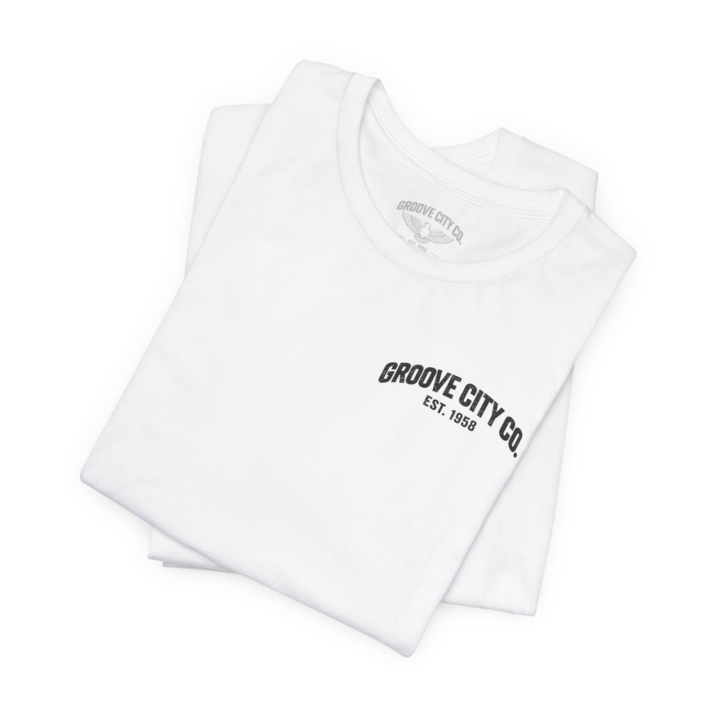 Folded white Groove City Co. vintage graphic T-shirt featuring a retro chest logo and custom light gray eagle inner neck label.