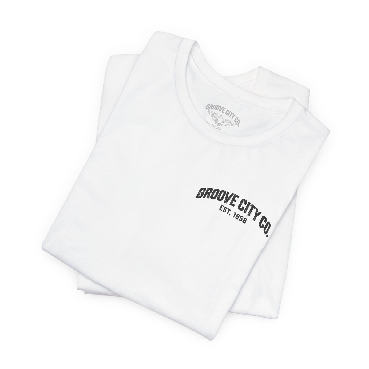 Folded white Groove City Co. vintage graphic T-shirt featuring a retro chest logo and custom light gray eagle inner neck label.