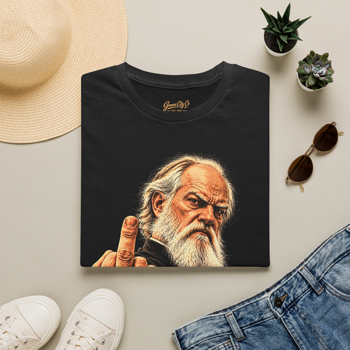 Holy Attitude black vintage rebel priest T-shirt folded flat with Groove City Co. neck label, styled with jeans and accessories.